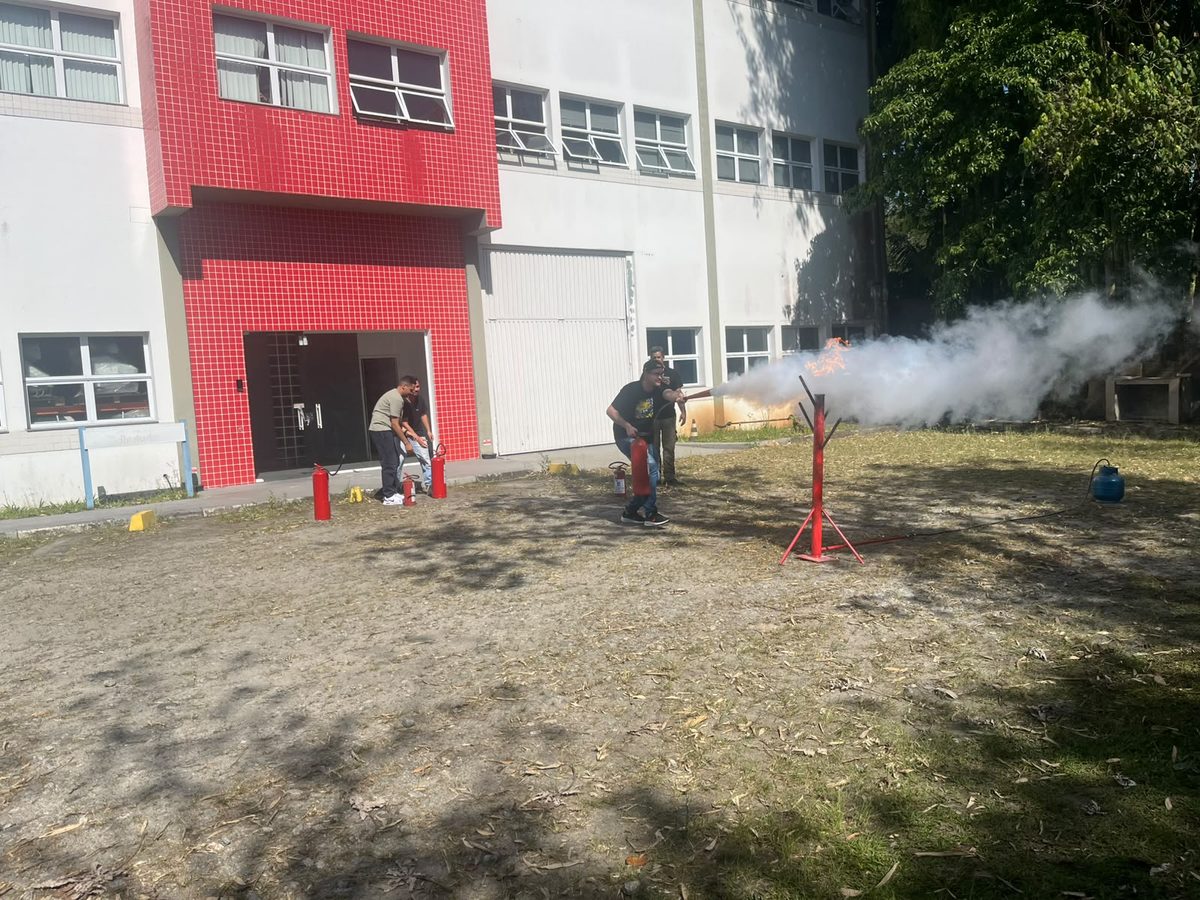 Brigada de incêndio combatendo fogo à noite com mangueira